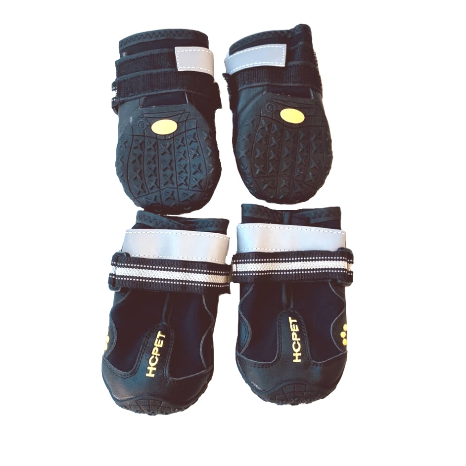 Pair of black pet boots with white soles on a white background