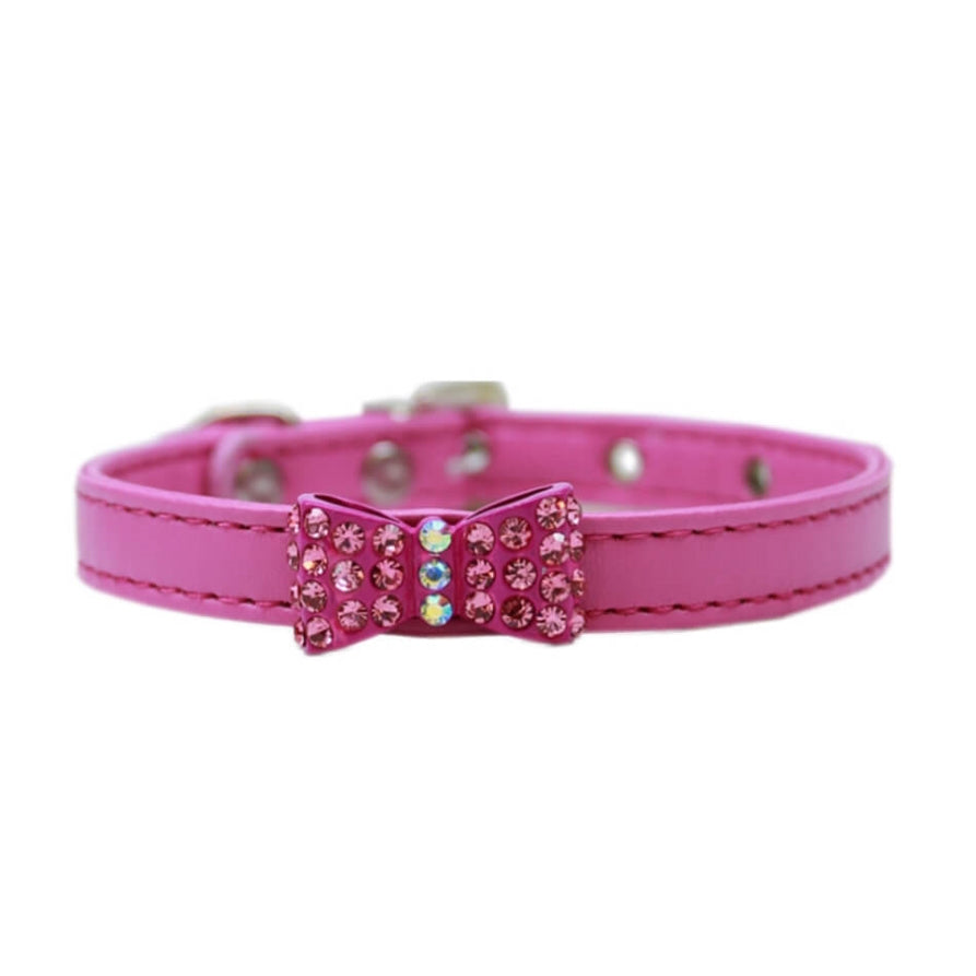 Pink dog collar with a decorative bow and rhinestones on a white background
