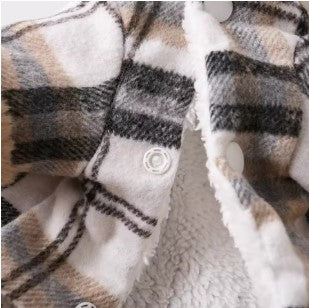 Close-up of a plaid fabric with brown, beige, and black colors.