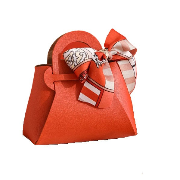 Red handbag with a decorative bow on a white background